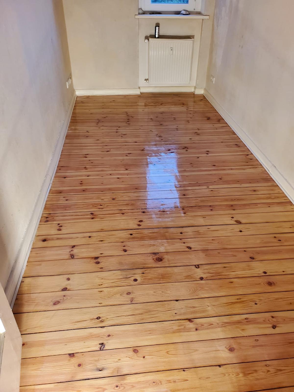 Nachher – frisch aufgearbeiteter, glänzender Holzboden nach Renovierung durch TKR Gebäudeservice